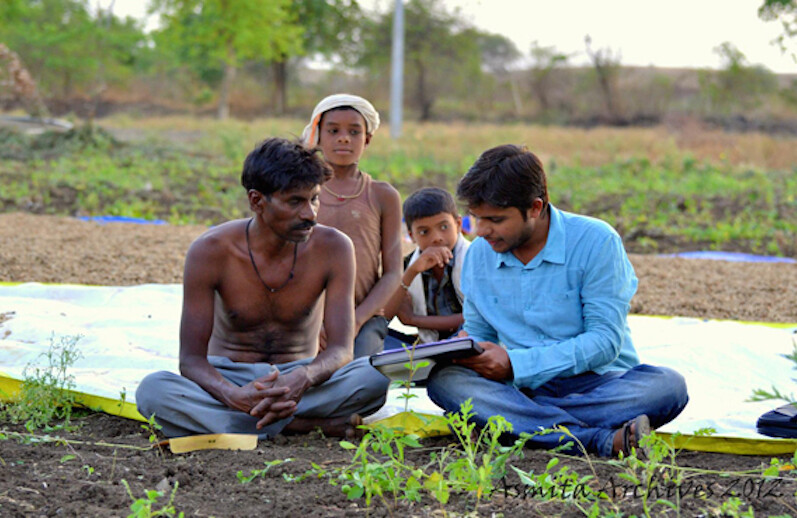 Un travailleur d'Asmita avec un agriculteur et sa famille.  Avec l'aimable autorisation d'Asmita