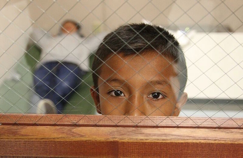 Child at a U.S. Customs and Border Protection facility, 2014. CREDIT: <a href="https://commons.wikimedia.org/wiki/File:CBP_Processing_Unaccompanied_Children_(15020197208).jpg"> Eddie Perez</a> , U.S. Customs & Border Protection, public domain