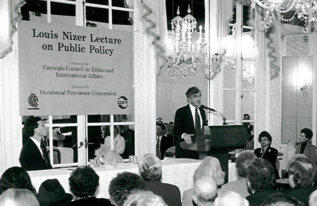 Joel Rosenthal sentado a la mesa, Elie Wiesel en el podio, Conferencia Louis Nizer, 1996