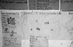 With limited resources, Guarani students paper a village school's adobe walls with writing in Guarani and Spanish.