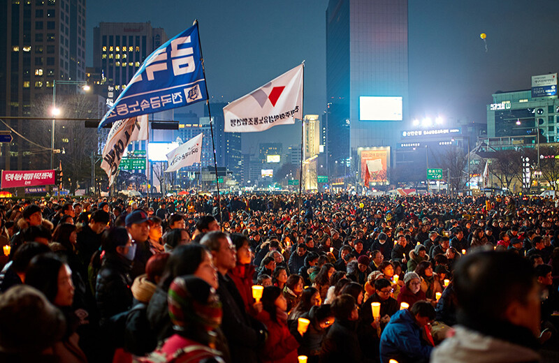 Protesters of President Park Geun Hye in Seoul, South Korea. CREDIT: <a href=https://commons.wikimedia.org/wiki/File:Protest_Of_President_Park_Geun_Hye_(191877143).jpeg>Mathew Schwartz (CC)</a>