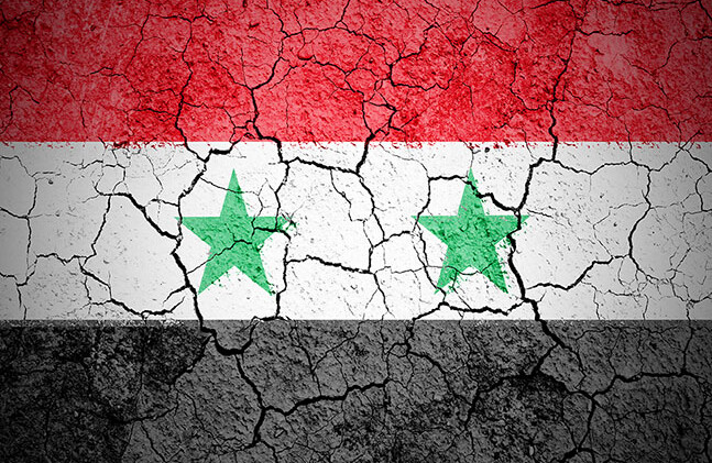 CREDIT: <a href="http://www.shutterstock.com/pic-111913646/stock-photo-the-syria-flag-painted-on-cracked-ground-with-vignette.html?src=2MxIh1ofNEDYTajaWexBqA-1-79">The Syrian flag</a> via Shutterstock