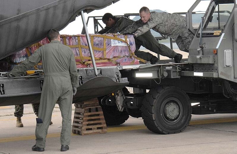 U.S. servicemembers load humanitarian relief supplies for victims of Cyclone Nargis. Yokota Air Base, Japan, 2008. CREDIT: <a href=https://commons.wikimedia.org/wiki/File:080512-F-1590C-553_Loading_relief_supplies_at_U-Tapao.jpg>U.S. Air Force (CC)</a>.