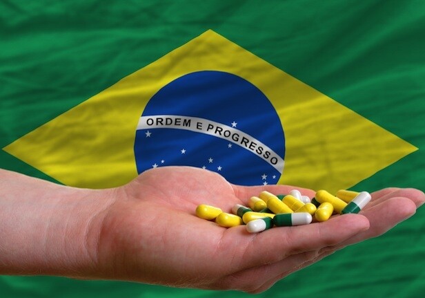 CREDIT: <a href="http://www.shutterstock.com/pic-106093970/stock-photo-man-holding-capsules-in-front-of-complete-wavy-national-flag-of-brazil-symbolizing-health-medicine.html">Shutterstock</a>