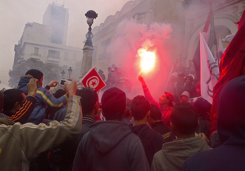 Youth celebrating the third anniversary of the Tunisian Revolution. <a href=https://www.flickr.com/photos/magharebia/11982827934/in/photolist-9bQgeD-9aAhCz-9dqsYW-9YgHcq-9bNYLG-9pkN1c-9cMpkH-9i9bv4-9mhsCr-9apkEC-abqUdk-9cgTqX-cefte3-abtJ1d-9xZ6qk-aqAfcJ-eh2E2X-auBAWG-9jUx8n-bmucdT-9EdQhn-9cDQ6m-9cQtbC-9cLmPn-9cMofP-jfT8gC-awWALv-ac1wAX-9jXBuu-9cQuqY-9i9by4-9gWkR1-9cPsoJ-9gTePa-9biquQ-9icgKW-9icgHo-9icRAJ-bu2vSb-9biqa7-9bhDvj-ap7TV8-9NVrKF-9VbGfx-9bfi7t-9biq41-9ckJ4f-9cMndn-26ZidB8-9i9bQ6>CREDIT: Magharebia (CC)</a>