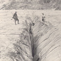 Standing between a giant fissure on a glacier, December 31, 1918. CREDIT: <a href="https://commons.wikimedia.org/wiki/Category:1919#/media/File:Standing_Between_A_Giant_Fissure_in_Glacier.jpg"> University of Colorado, Boulder</a>