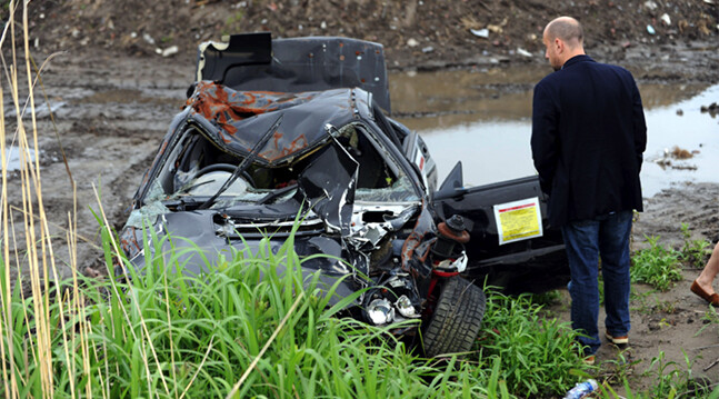 Photo: Allison Kwesell. Senior Fellow Devin T. Stewart examines a car destroyed by the March 2011 tsunami.