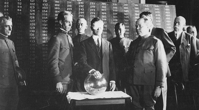 July 1917: U.S. Secretary of War, blindfolded, draws the first number in the draft lottery.