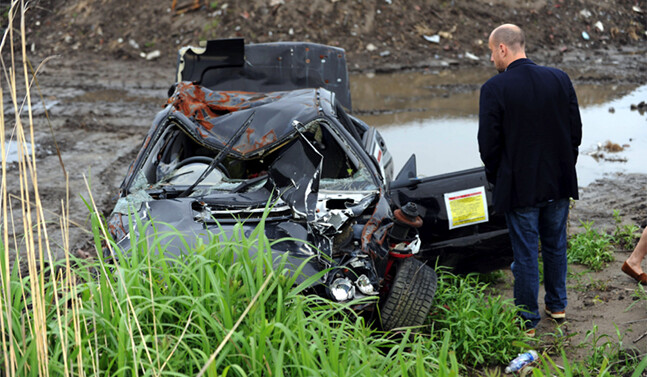 Photo: Allison Kwesell. Senior Fellow Devin T. Stewart examines a car destroyed by the March 2011 tsunami.