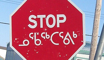 Nunavut stop sign in English and Inuktitut. CREDIT: <a href="http://flickr.com/photos/mafic/8930067/">Patrick Smillie</a> (<a href="http://creativecommons.org/licenses/by-nc-sa/2.0/deed.en">CC</a>).