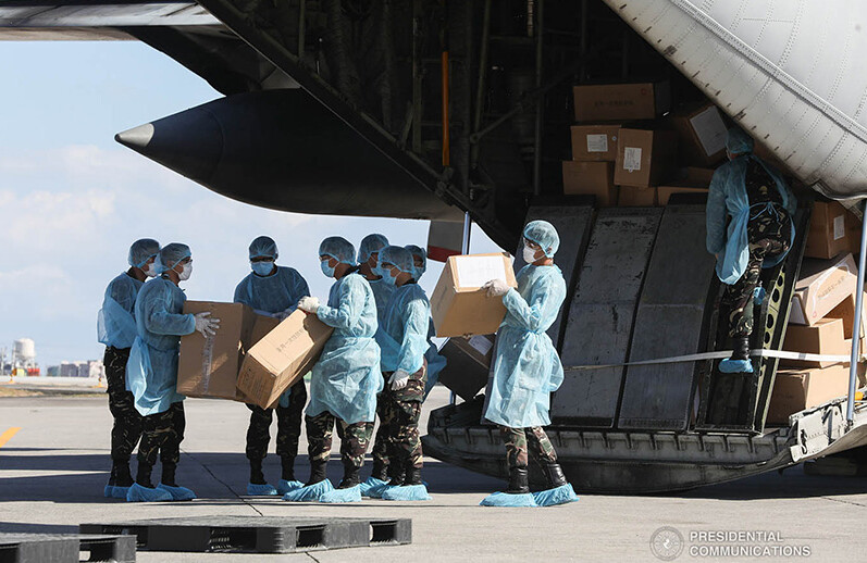 Aid packages from China are unloaded at the Villamor Air Base in Pasay City, Philippines on March 21, 2020. CREDIT: <a href=https://commons.wikimedia.org/wiki/File:China_COVID19_test_kit_PH_donation_7.jpg> Philippines Presidential Communications Operations Office (CC)</a>.
