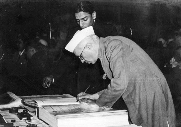 Jawaharlal Nehru signing the Indian Constitution in 1950.