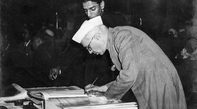 Jawaharlal Nehru signing the Indian Constitution in 1950.