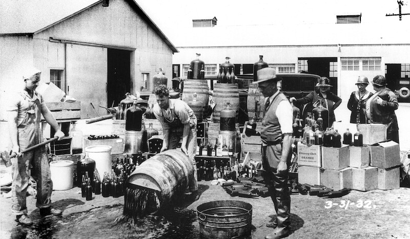 Orange County Sheriff's deputies dumping illegal alcohol, Santa Ana, California, 1932. CREDIT: <a href="https://commons.wikimedia.org/wiki/File:Orange_County_Sheriff%27s_deputies_dumping_illegal_booze,_Santa_Ana,_3-31-1932.jpg">Orange County Archives/(CC)</a>